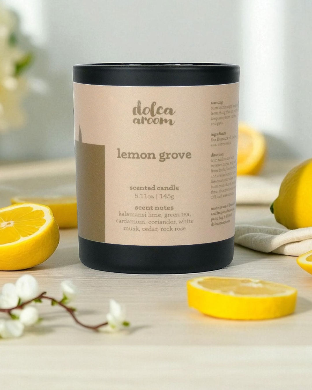 dolca aroom 5.11oz scented candle, lemon grove scent with lemons and flowers on a light surface