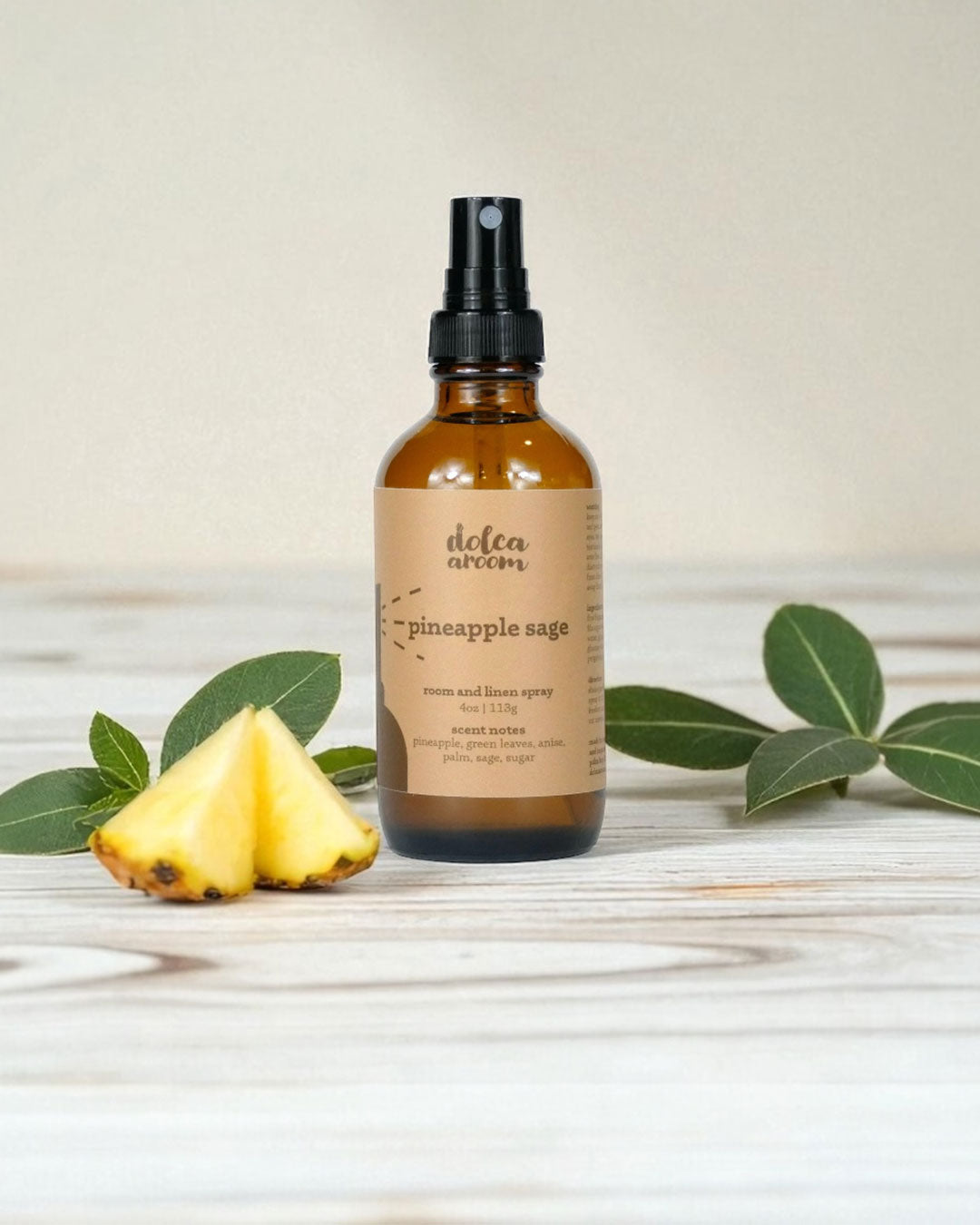 dolca aroom 4oz room and linen spray, pineapple sage scent with a pineapple and leaves on a light background